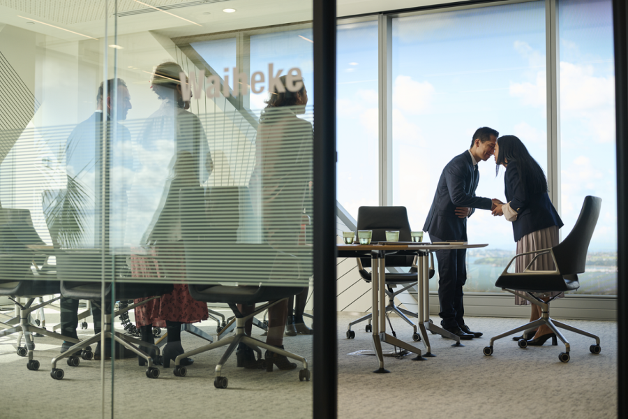 Representing a bi-cultural workplace. People in a meeting greeting each other with a hongi.